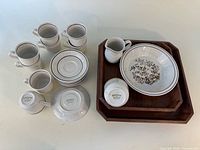 Stoneware cups, saucers, creamer, serving bowl, two wooden trays
