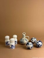Full lot showing three apothecary jars, vinegar jar, and three ceramic balls