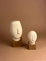 Both head sculptures front view on neutral background