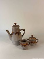 Front view of teapot, creamer and sugar bowl showing overall form and glaze