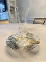 Overall view of clear glass decanter showing abstract multicolor design and shape