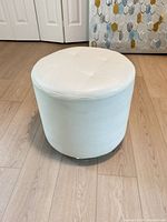 Full view of ottoman showing overall shape and upholstery