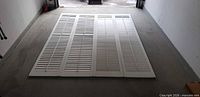 Four white California shutter panels laid side by side