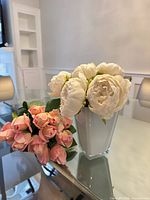 Bouquets and vase on glass table, showing both items together