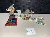 Group view of all figurines, wall pocket, vase and plaque