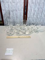 Front view showing six etched goblets and two vineyard glasses with ruler for scale