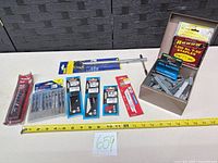 All items arranged: basin wrench, various blade packs, staple box