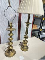 Both brass table lamps side by side showing height difference, shade, patina, cords, and overall condition