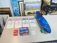 Group shot of all items including skateboard, Disney bag packs, Coca-Cola cards, Underdog tin