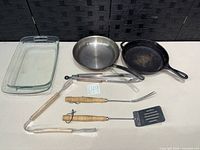 Group shot of baking dish, two skillets and three grill utensils