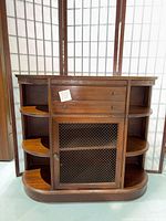 Front view of full cabinet showing drawers, wire mesh door and side shelves