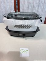 Slow cooker assembled with glass lid on black base