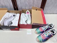 Overall shot of three pairs of sneakers in and out of boxes