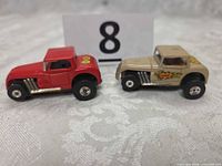 Red and tan Aurora slot cars side view