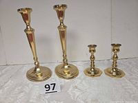 Four brass candlesticks, two tall and two short, group view