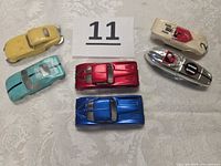 Top view of six Aurora HO slot car bodies showing colors and numbers