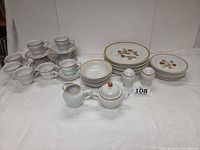 All pieces arranged showing cups, saucers, plates, bowls, creamer, sugar, shakers
