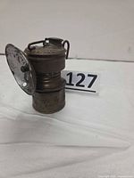 Front angled view of brass carbide lamp showing reflector and size