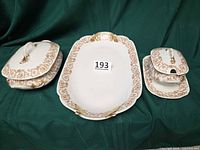 three-piece Limoges serving set displayed on green cloth