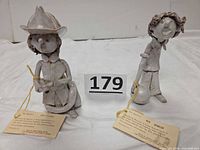 Front view of both figurines with hang tags