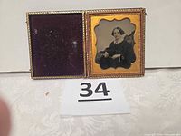 Open case showing velvet pad and framed photograph