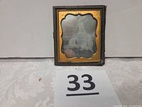 Front view of cased photograph showing image and brass mat