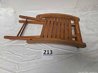 stool folded flat showing slatted seat and curved rails