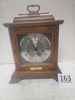 Full view of Hamilton mantle clock showing wooden case, dial, and plaque