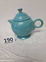Left-front view of turquoise Fiesta teapot with lid and ring handle