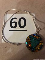 Necklace laid flat showing pendant design and chain