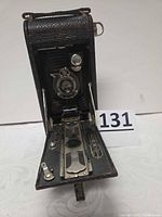 Front view of camera partially opened showing lens, bellows and front plate