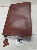 Front view of brown leather zippered portfolio case with curved seam detail