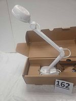 Document camera in open box showing arm, camera head and base