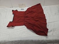 Full view of red and black polka-dot child’s dress