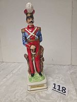 Full view of ceramic soldier decanter on base with plaque
