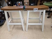 Front view of both saddle stools showing seats and white frames