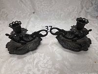Both cast iron candlestick holders side by side