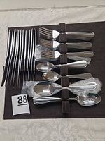 Flatware pieces arranged on felt holder showing knives, forks, spoons
