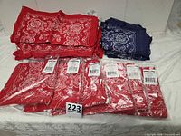 Stack of sealed red bandanas, loose red bandanas, loose blue bandanas