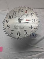 Front view of Sears saw blade clock showing full face, numerals and hands
