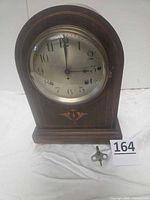 Front view of Seth Thomas mantel clock showing overall form, dial, and key