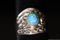 Front close-up of silver ring showing opal stone and filigree detail