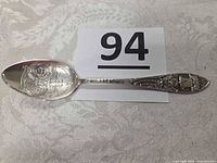 Full view of spoon front showing bowl engravings and handle relief