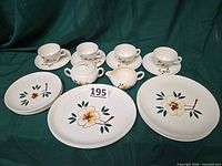 Full set arranged showing plates, cups, saucers, creamer, sugar bowl