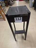 Full view of tall wooden plant stand front angle