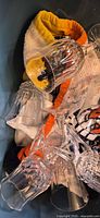 Crystal and glass drinkware piled in bin with towels