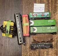 Group shot of seven HO rolling stock cars and two yellow track controllers with wiring
