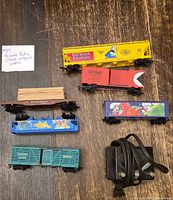 All five freight cars and power pack displayed on floor