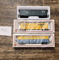 Three HO scale boxcars, two boxed, one loose