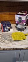 Overall lot showing boxed pot set, boxed fondue set, speckled stockpot, grey round platter and yellow square platter
